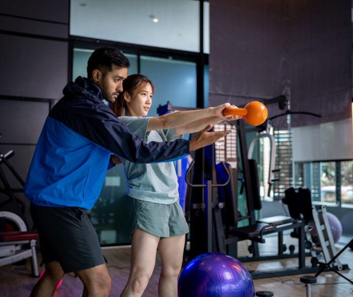 Asian man and woman working out, one is a trainer, the other is an exerciser