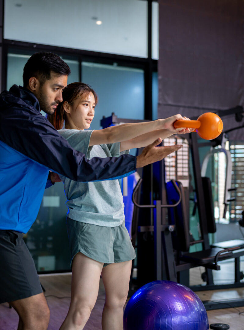 Asian man and woman working out, one is a trainer, the other is an exerciser